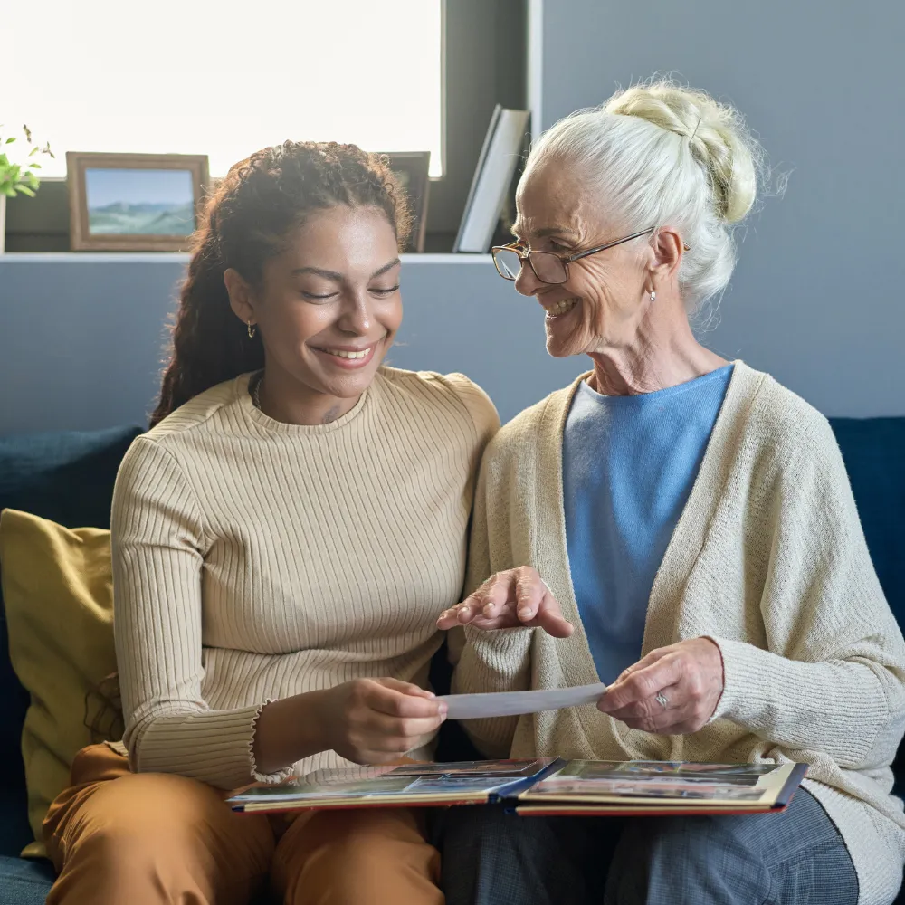 Senior showing photos and talking to caregiver