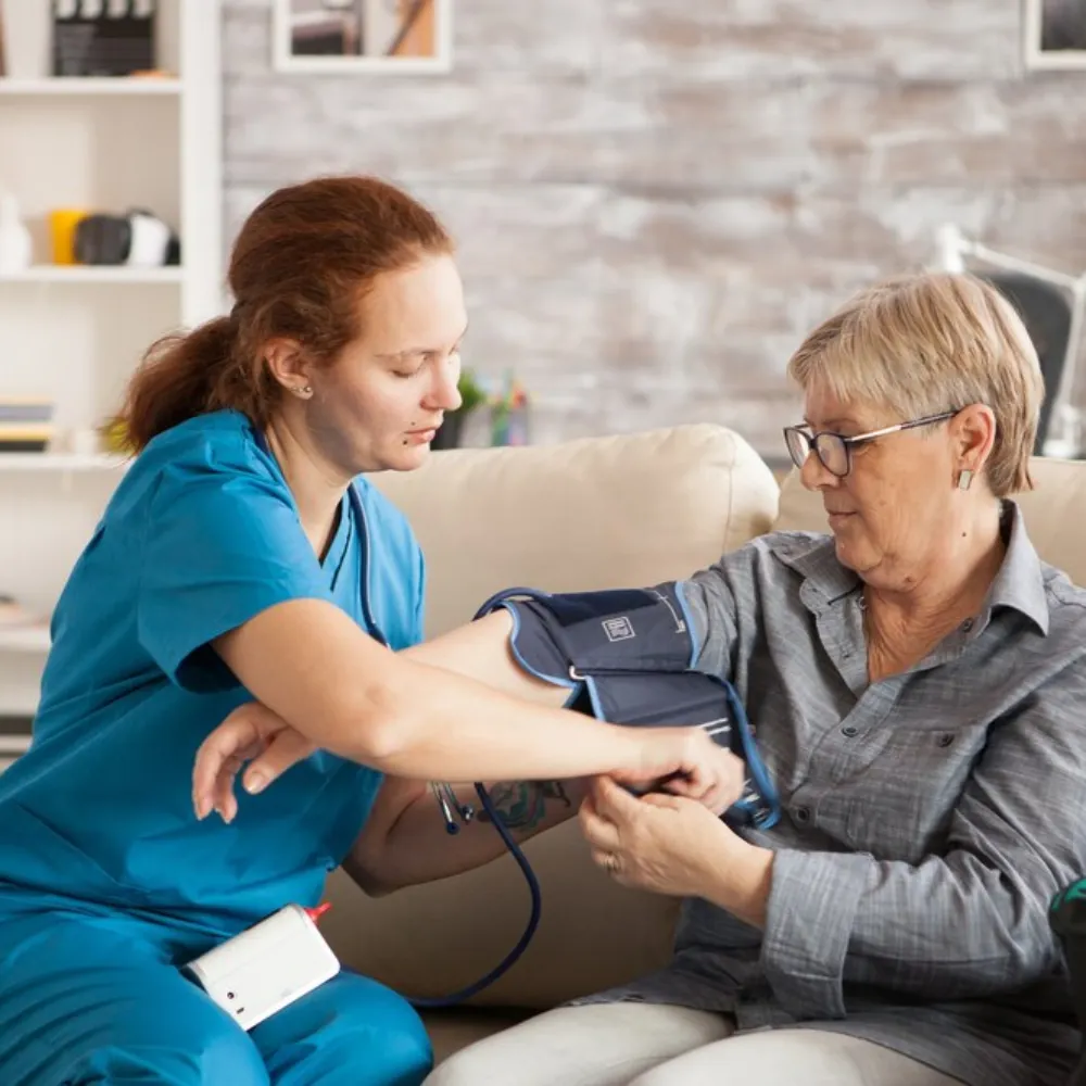 Nurse checking senior woman's blood pressure